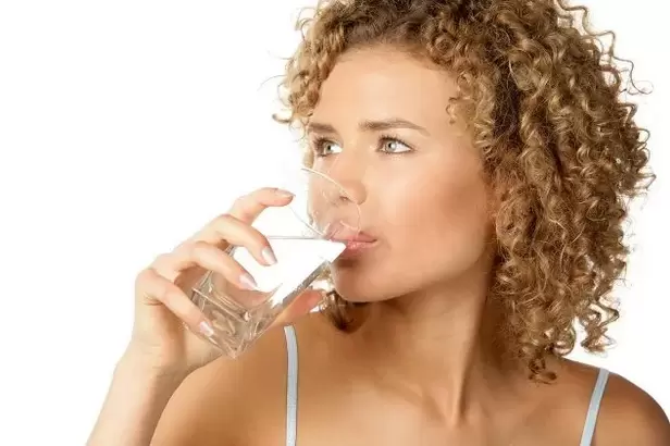 The girl follows a diet for the lazy, drinking a glass of water before eating